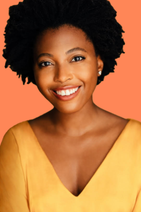 Woman with an afro and yellow shirt smiling